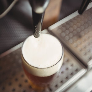Close-up of beer glass with froth in a bar